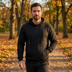 Man wearing the Arosa Textured Quarter-Zip Hoodie in Midnight Black on an autumn walk in the park