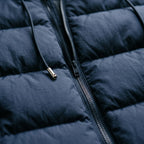 Close-up of the quilted baffles, zip and metal-tipped drawstring in Navy Blue